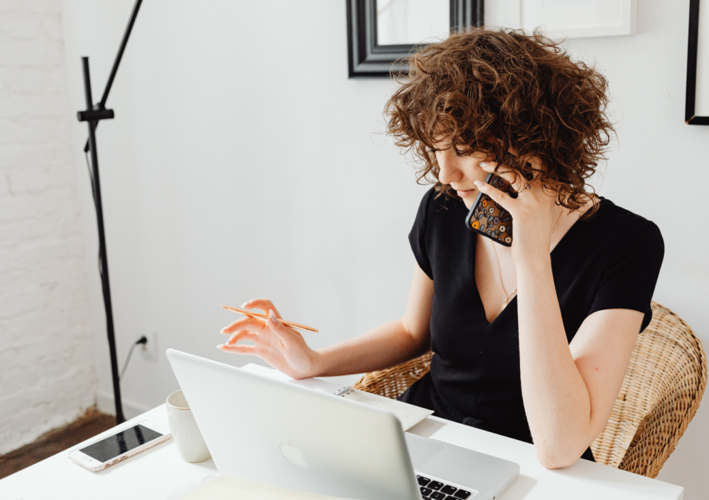 A person sitting at a desk talking on the phone