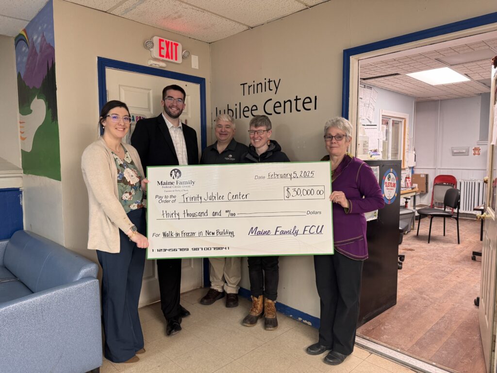 A group of people pose with a big check to show a donation made to Trinity Jubilee Center